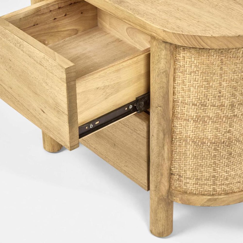 Wooden side table with open drawer and wicker basket on a white background